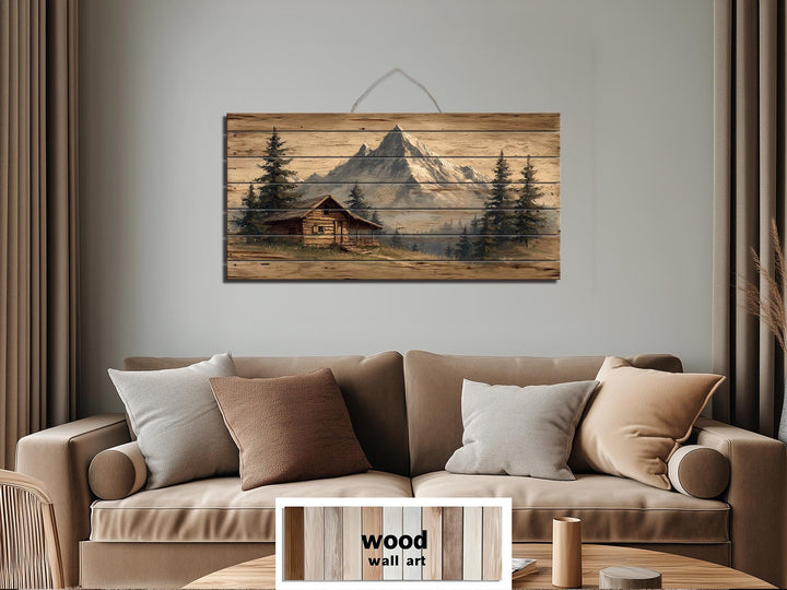 Mountain cabin distressed wood wall art with a log cabin and mountains.