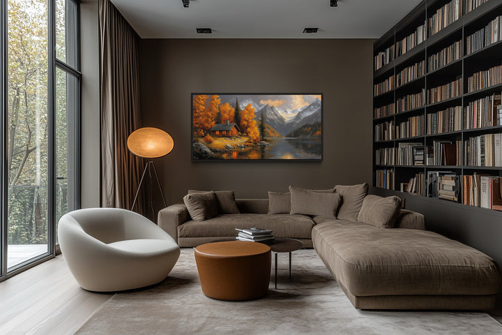 Mountain cabin wall art with warm autumn colors hanging in a modern living room with a brown sofa.