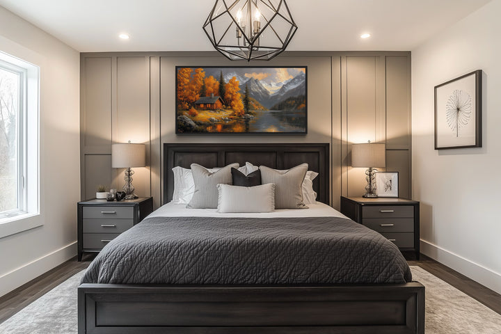 Mountain cabin wall art canvas with warm autumn colors hanging above a bed in a modern bedroom.