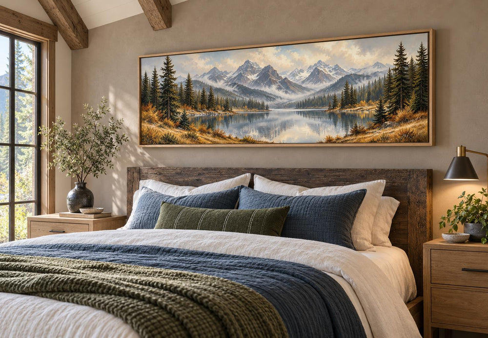 Long horizontal canvas art of a mountain lake and autumn forest above a bed in a rustic room.