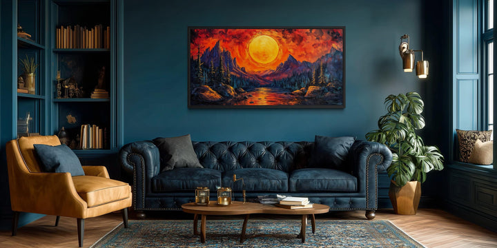 Mountain Lake Fiery Sunset canvas wall art displayed above a blue sofa in a modern living room.