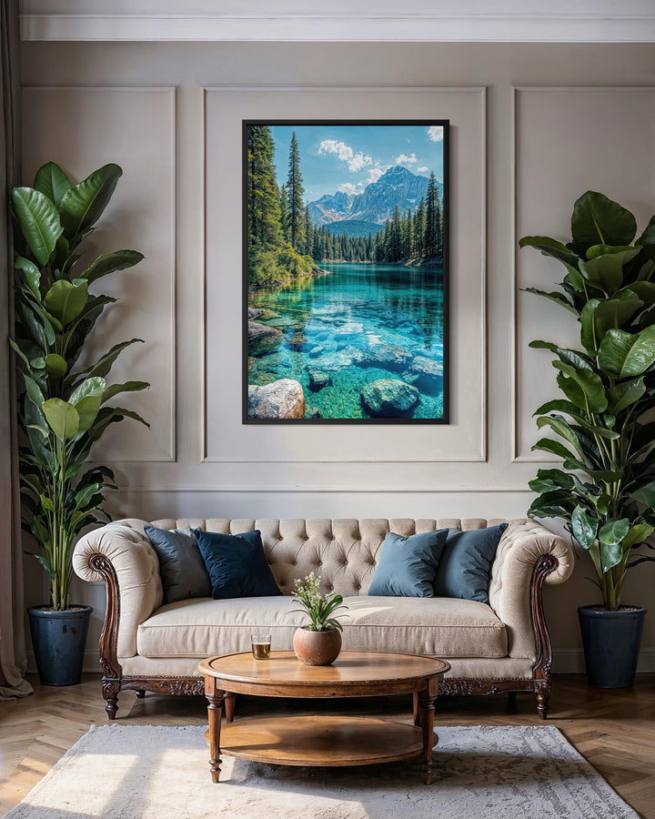 Vertical canvas wall art of a clear mountain lake scene hanging above a sofa in a living room.