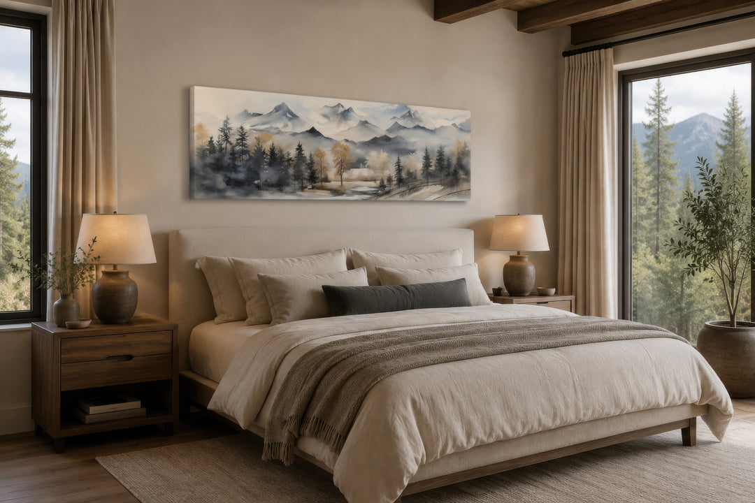 Horizontal watercolor mountain landscape canvas wall art in earth tones hanging above a bed.