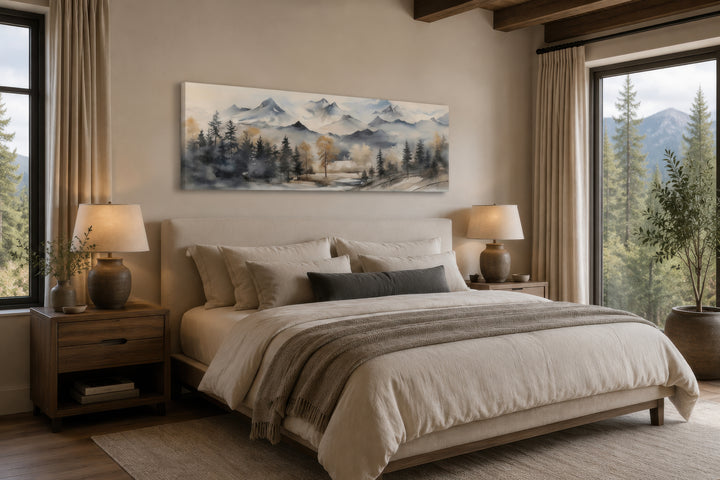 Horizontal watercolor mountain landscape canvas wall art in earth tones hanging above a bed.