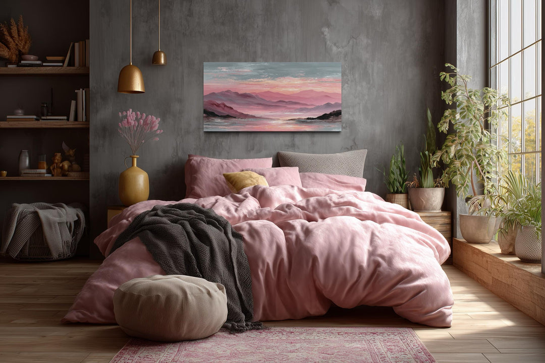 Horizontal canvas print of a pink mountain landscape at sunset hanging above a bed.