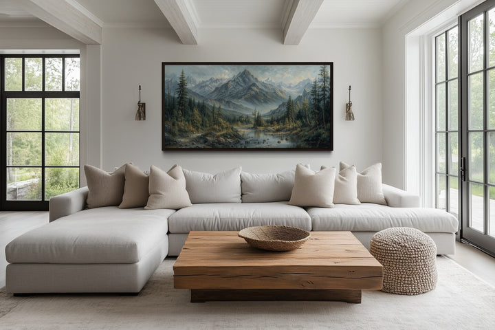 Mountain river landscape framed canvas art above a modern sofa in a rustic living room.