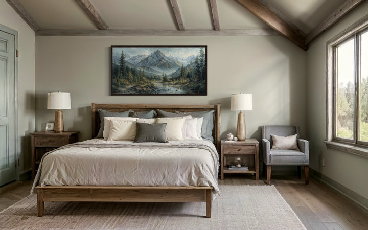 Mountain river landscape framed canvas art above a wooden bed in a rustic bedroom.