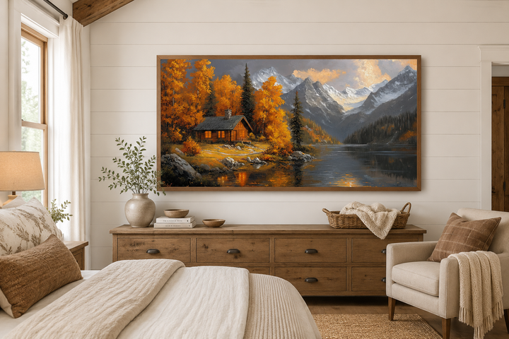 Rustic mountain cabin wall art with warm autumn colors and a lake, framed above a wooden dresser.