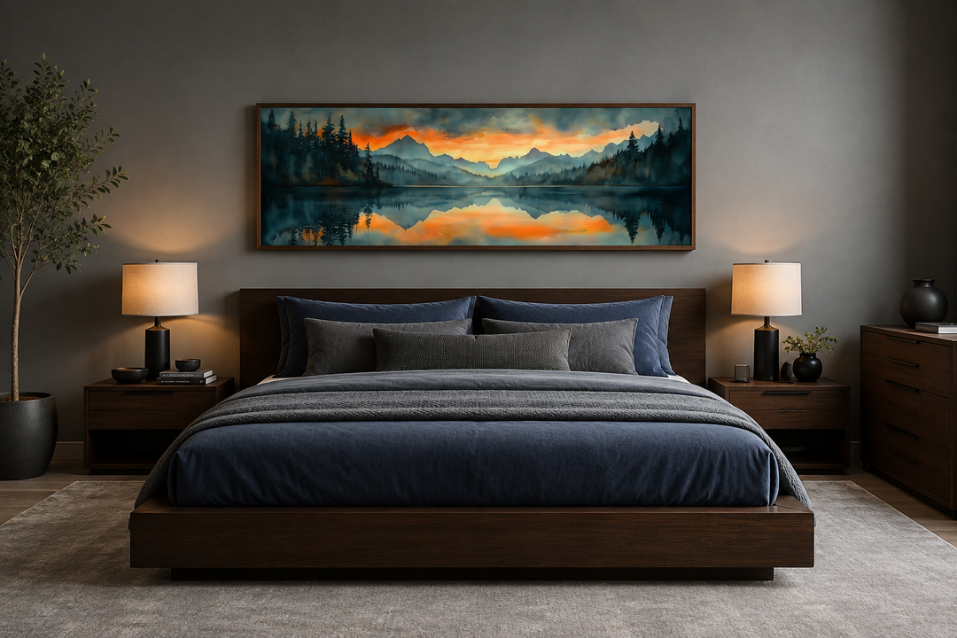 Horizontal watercolor painting of a mountain lake sunset hanging above a dark wood bed frame.