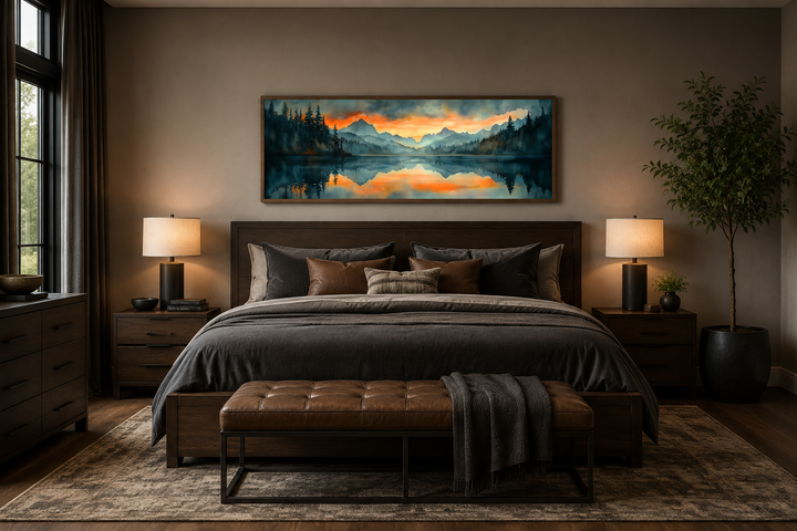 Mountain lake sunset watercolor landscape wall art hanging above a bed in a modern bedroom.