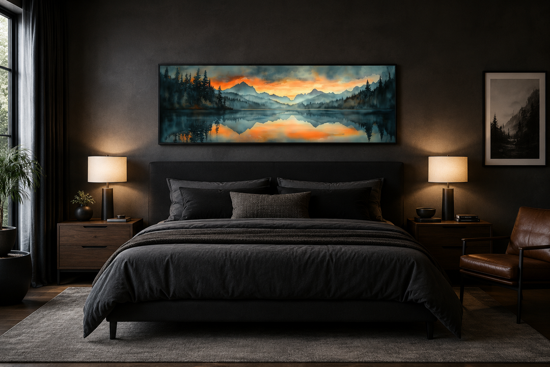 Horizontal watercolor painting of a mountain lake sunset hanging above a bed in a dark bedroom.