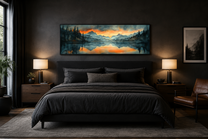 Horizontal watercolor painting of a mountain lake sunset hanging above a bed in a dark bedroom.