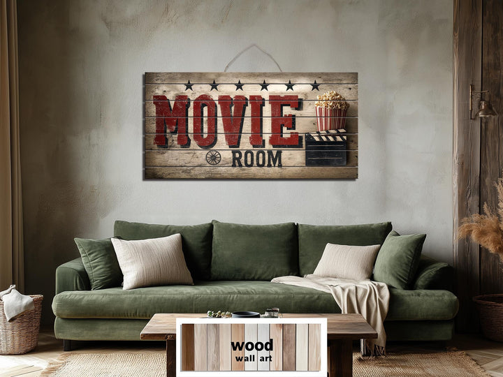 Rustic wood wall art featuring a distressed Movie Room print hangs above a green sofa.
