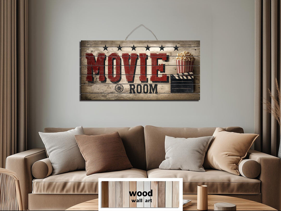 Rustic wood movie room wall art with distressed red lettering hanging above a tan sofa.