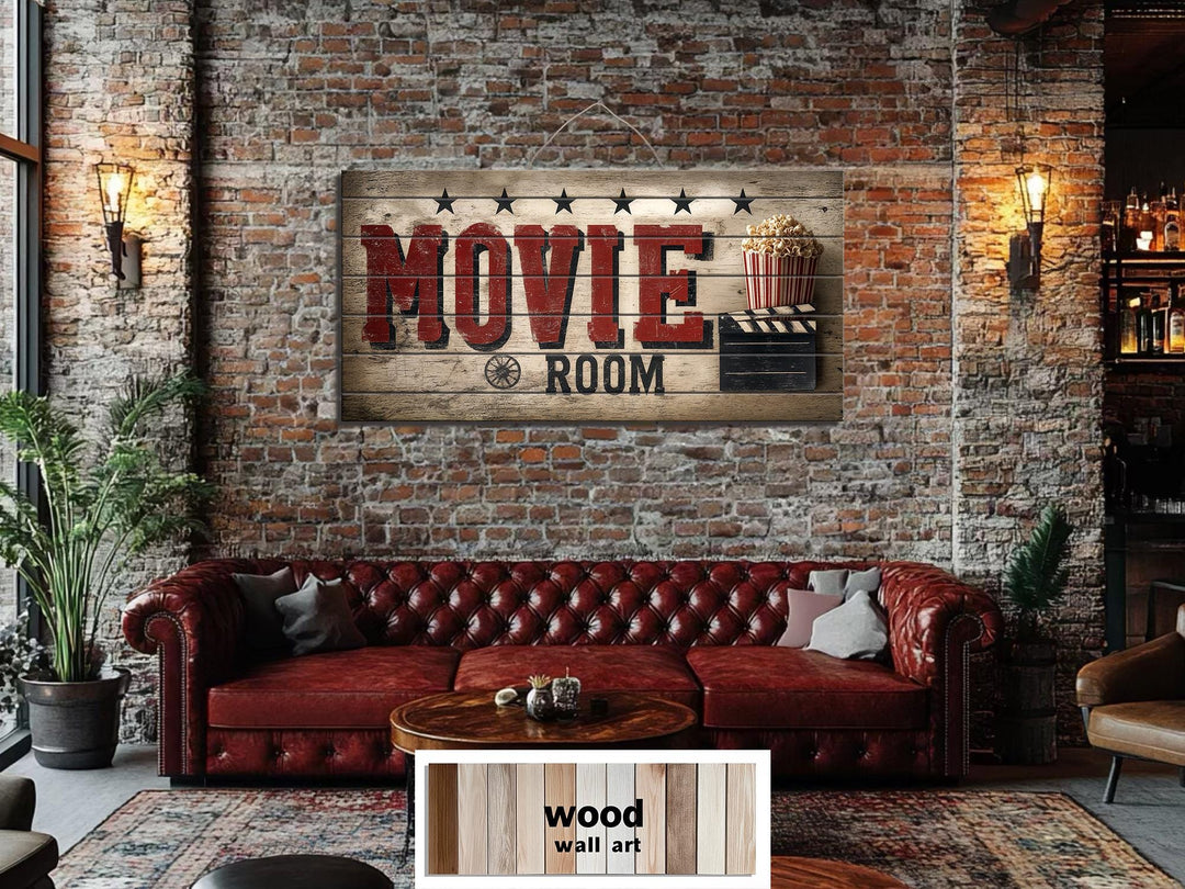 Rustic wood sign with distressed red MOVIE ROOM text hanging on a brick wall above a leather sofa.
