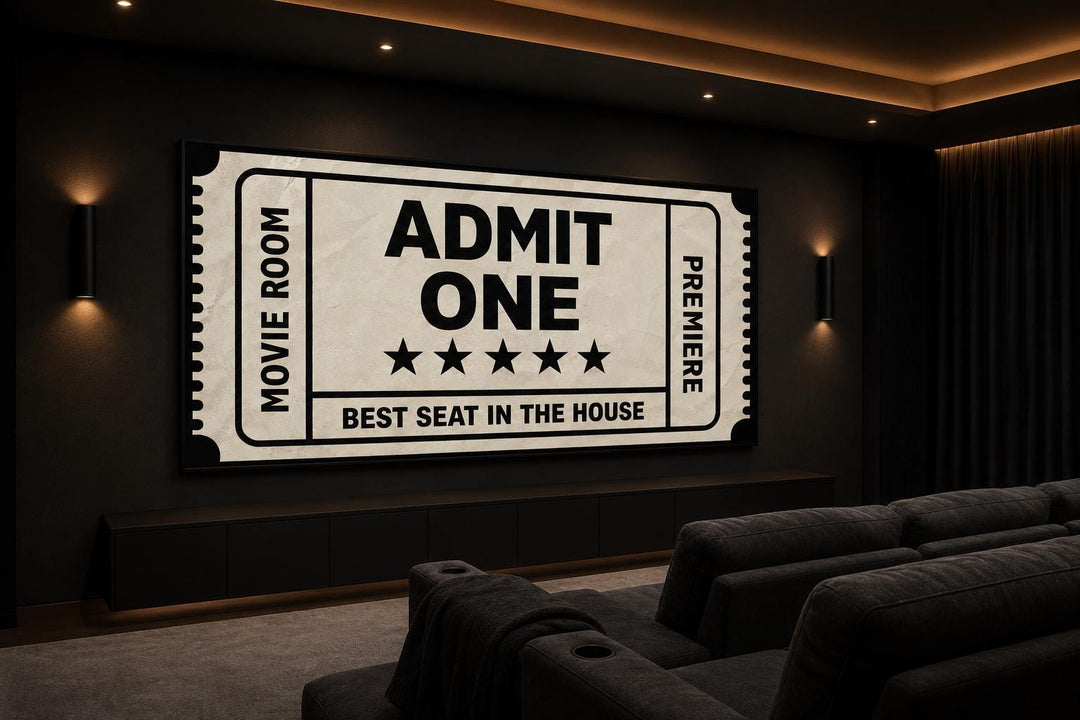 Vintage-style movie ticket canvas art on a dark wall in a home theater with tiered seating.
