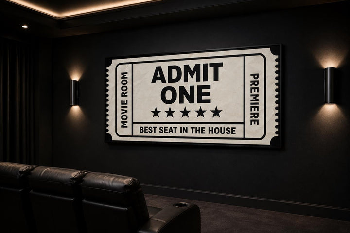 Vintage-style movie ticket canvas art on a black wall in a home theater with leather seating.