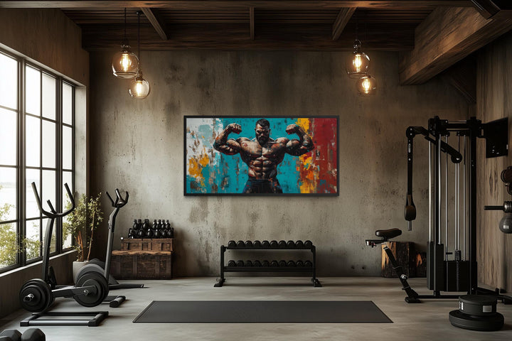 A framed canvas of a muscular man flexing hangs in a modern, industrial-style home gym.