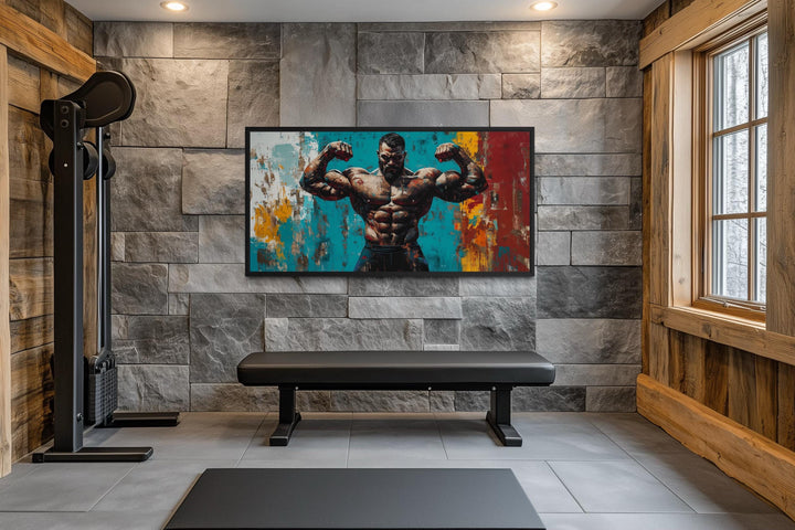 A framed canvas of a muscular man flexing against a colorful abstract background in a home gym.