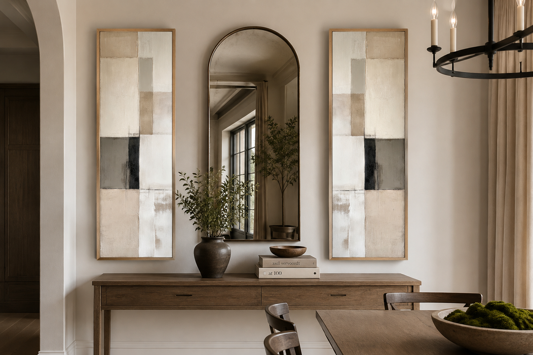Two tall, narrow neutral geometric abstract canvas prints flanking an arched mirror on a console.