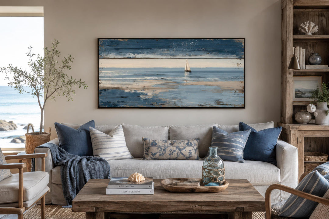 Nautical wall art featuring a lone sailboat on a calm blue ocean with a distressed wood-look frame.