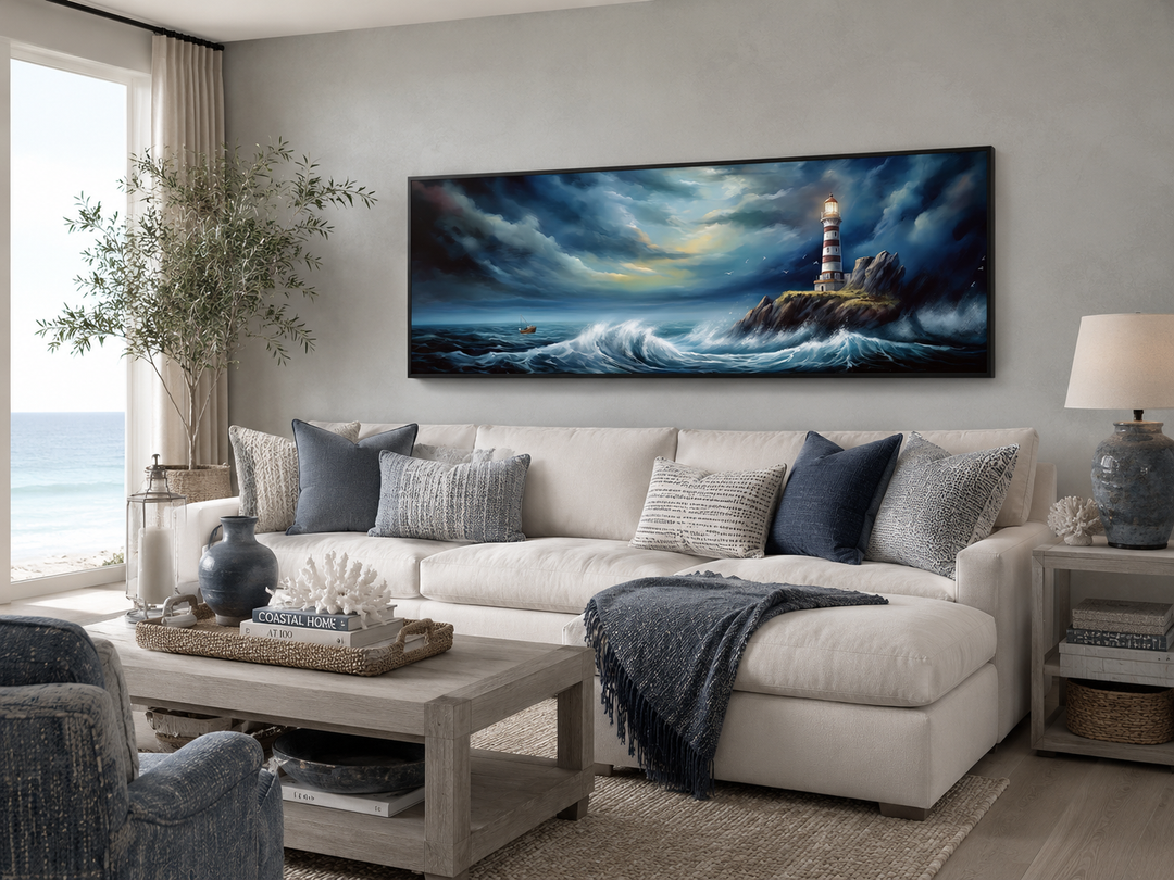 Dramatic horizontal wall art of a lighthouse in a stormy ocean above a white sofa in a living room.