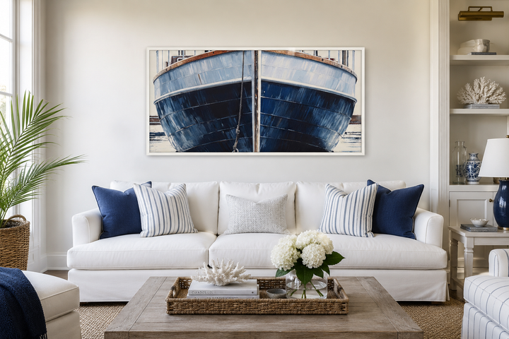 Navy blue rustic boat painting nautical framed canvas wall art above a white sofa in a living room.