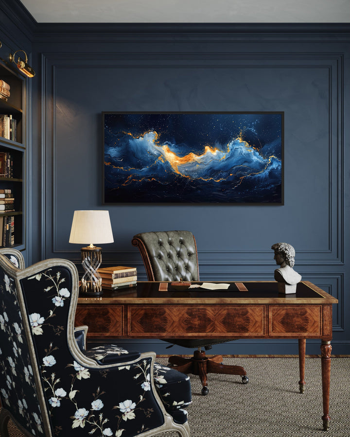 Abstract navy blue and gold ocean wave canvas art hanging above a wooden desk in a classic office.