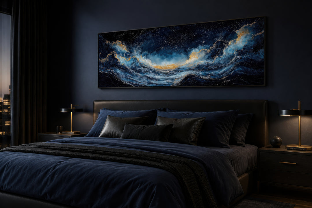 Navy blue and gold ocean wave horizontal canvas wall art hanging above a bed in a dark bedroom.