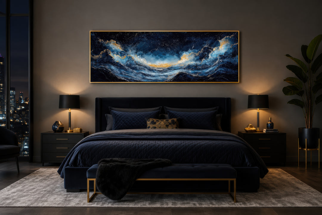 Navy blue and gold ocean wave horizontal canvas wall art hanging above a dark blue velvet bed.
