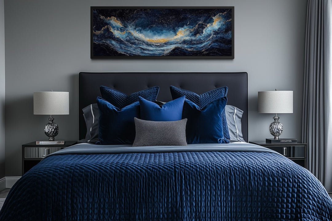 Navy blue and gold ocean wave horizontal canvas wall art hanging above a bed in a modern bedroom.
