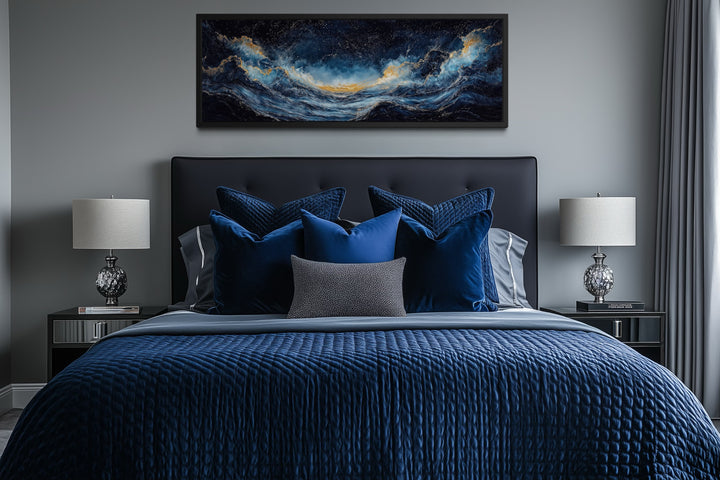 Navy blue and gold ocean wave horizontal canvas wall art hanging above a bed in a modern bedroom.