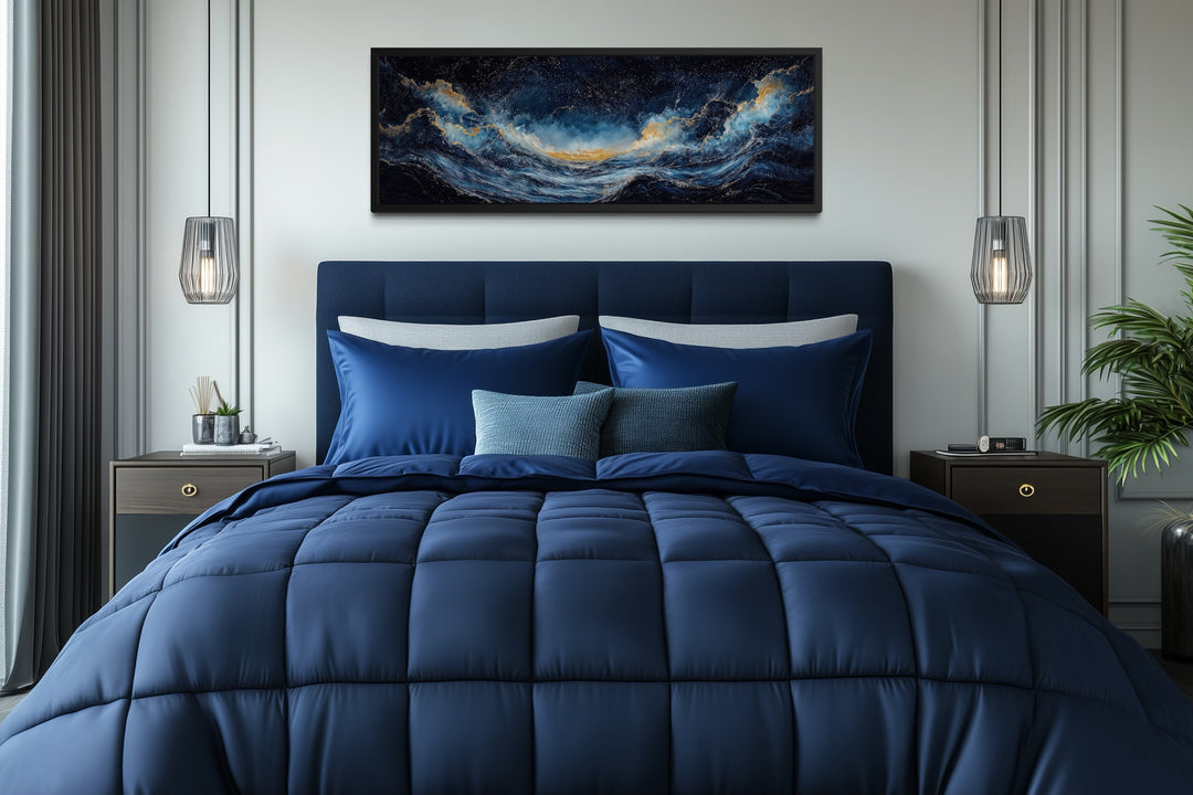 Navy blue and gold ocean wave horizontal canvas wall art hanging above a bed in a modern bedroom.
