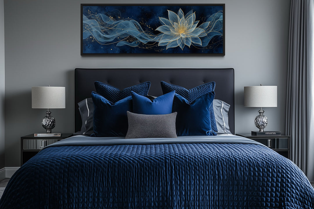 Navy blue and gold minimalist lotus flower canvas wall art hanging above a bed.