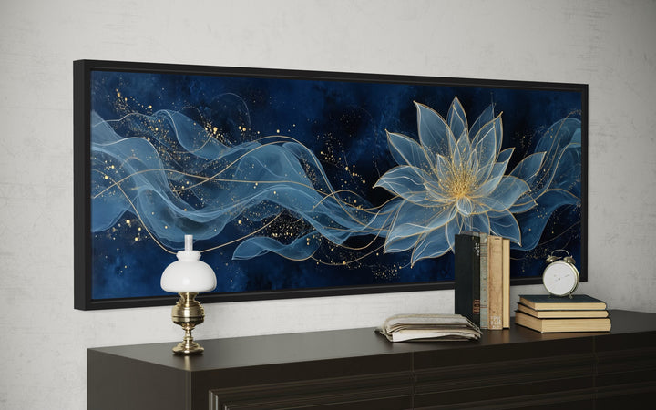 Navy blue and gold minimalist lotus flower canvas wall art above a dark wood console table.