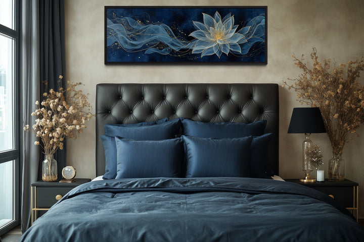 Horizontal navy blue and gold minimalist lotus flower canvas art hanging above a bed.