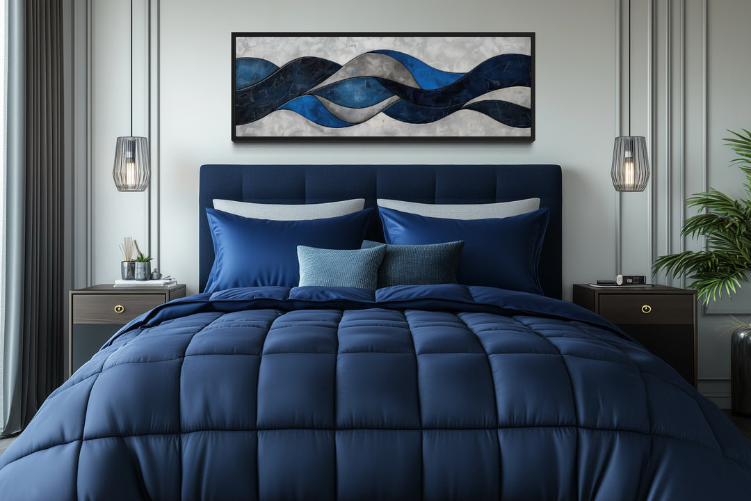 Navy blue and grey geometric abstract canvas wall art hanging above a bed in a modern bedroom.