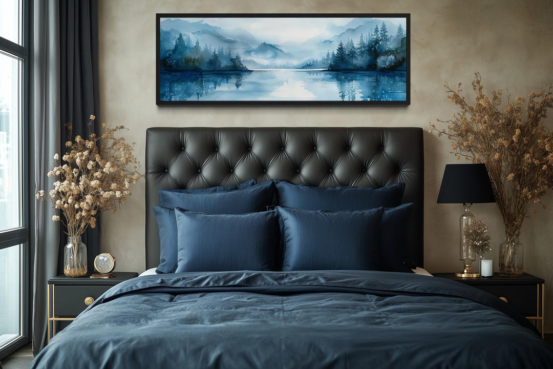 Navy blue minimalist lake landscape panoramic wall art above a bed.