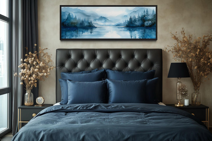 Navy blue minimalist lake landscape panoramic wall art above a bed.