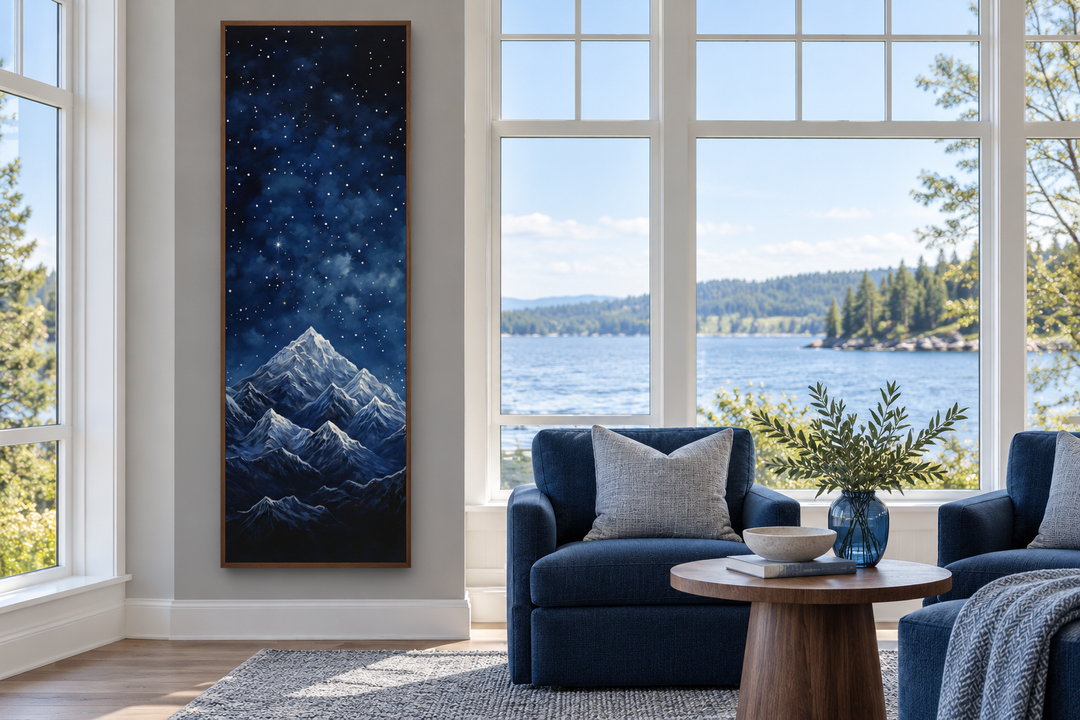 Tall narrow vertical framed canvas art of a navy blue starry night sky over snowy mountains.