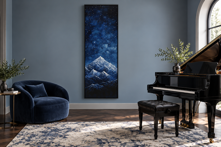 Tall narrow vertical framed canvas art of a navy blue starry night sky over snowy mountains.