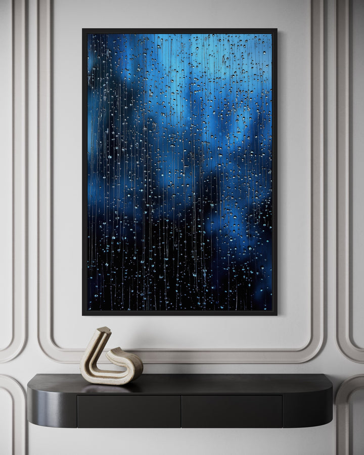 Navy blue rain drops framed canvas wall art hanging above a black console table with a sculpture.