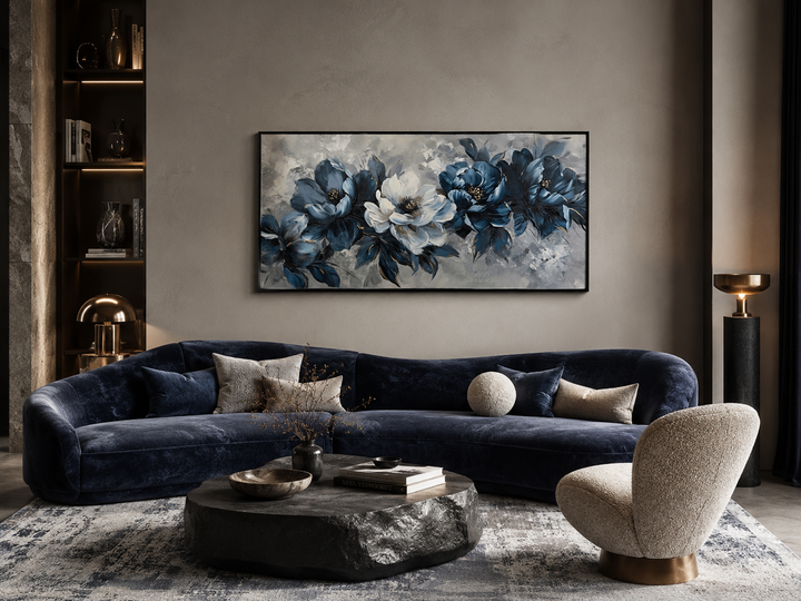 Framed navy blue and white abstract floral canvas art hanging above a curved velvet sofa.