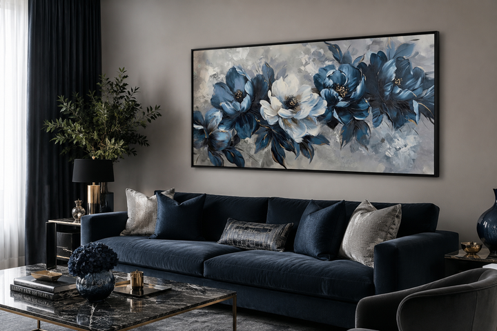Navy blue and white abstract floral canvas wall art in a black frame above a navy velvet sofa.