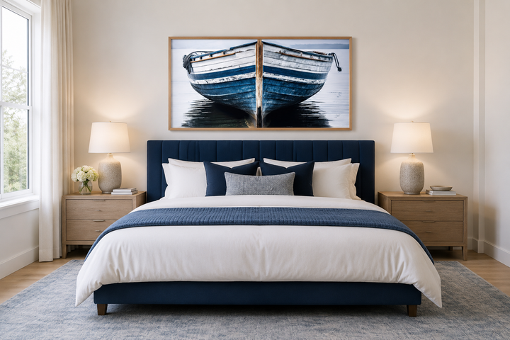 Navy blue and white old boat painting framed canvas wall art hanging above a bed in a bedroom.