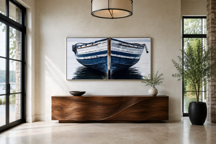 Framed canvas wall art of a navy blue and white old boat, centered above a wooden console table.