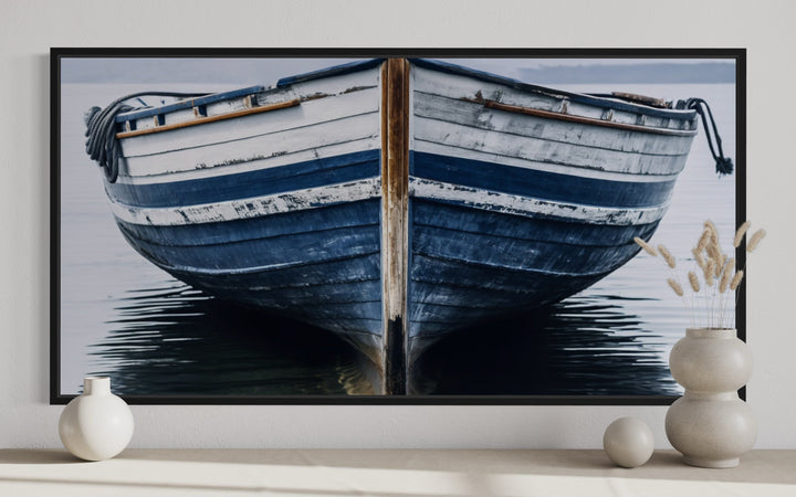 Navy blue and white old boat painting on framed canvas wall art above a console table.