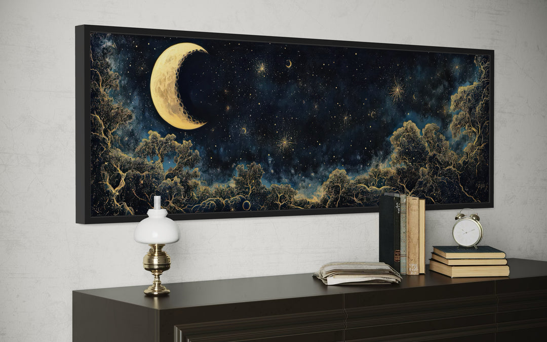 Navy blue and gold horizontal wall art of a crescent moon and starry sky above a dark wood dresser.