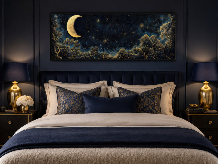 Navy blue and gold moon crescent long horizontal wall art hanging above a bed in a dark bedroom.