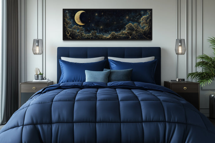 Navy blue and gold moon crescent long horizontal wall art hanging above a bed in a bedroom.